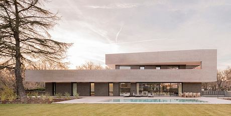 A modern, minimalist single-story home with a pool, large windows, and a flat roof.