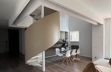 Modern minimalist living room with angular architectural elements and wood flooring.