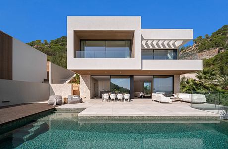 Sleek modern villa with minimalist architecture, expansive glass walls, and an infinity pool.