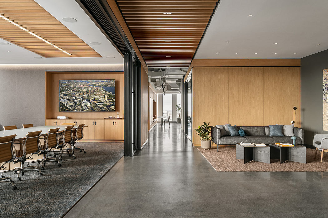 An open-concept office space with modern wood and concrete finishings, artwork, and comfortable seating.