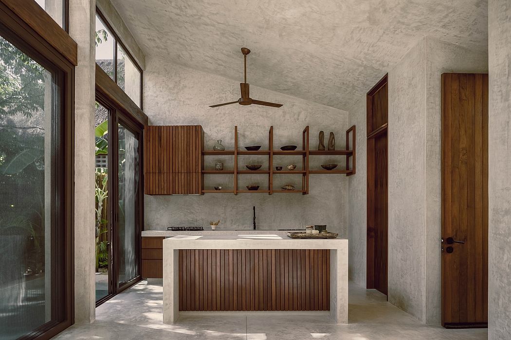 A minimalist kitchen interior with wooden shelves, a concrete countertop, and a ceiling fan.