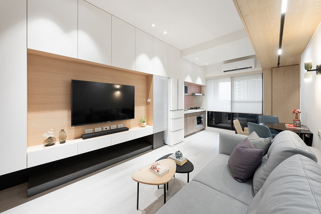 Sleek, minimalist living room with a large TV console, neutral color palette, and modern furniture.