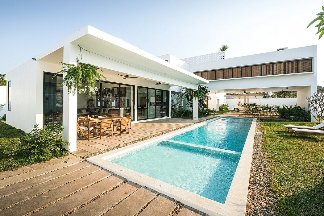 A modern, minimalist home with a sleek, open-air design, featuring a rectangular pool.