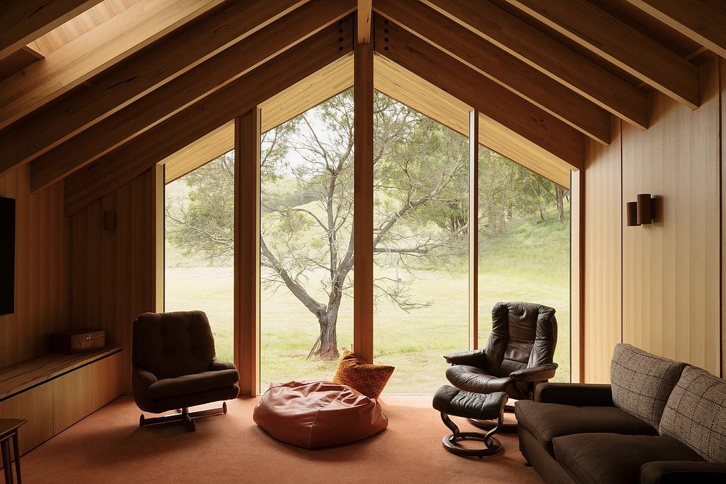 Cozy wooden cabin interior with panoramic forest views and plush seating.