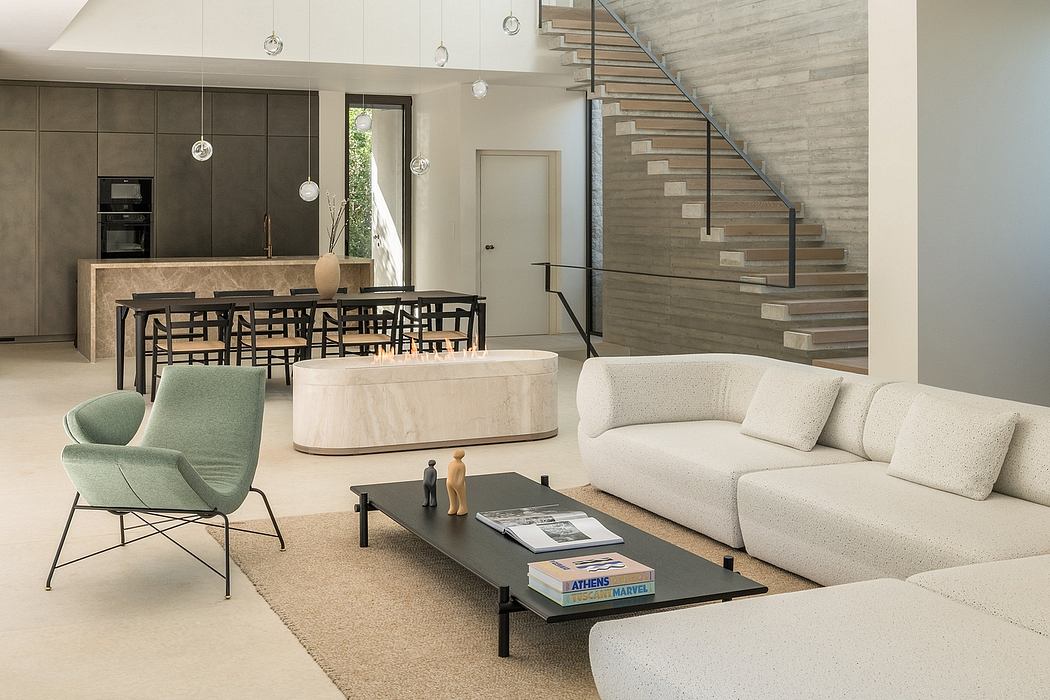 Spacious open-concept living area with modern furnishings, minimalist staircase, and pendant lighting.