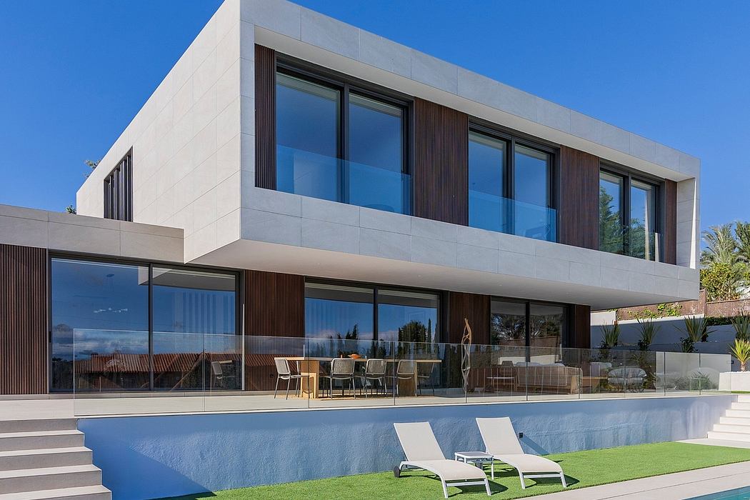 Modern, sleek house with clean lines, large windows, pool, and landscaped yard.