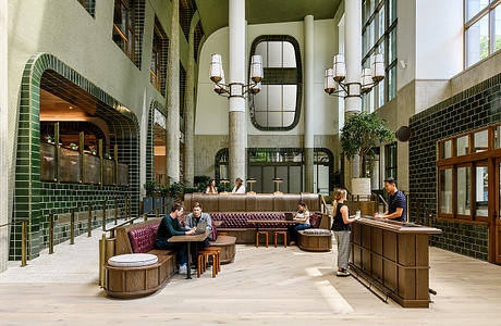 Elegant lobby with ornate arched windows, tiled walls, and plush seating arrangements.