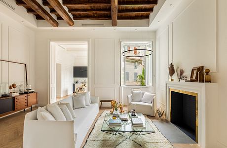 Elegant living room with vaulted wooden ceiling, white couches, glass-top coffee table.