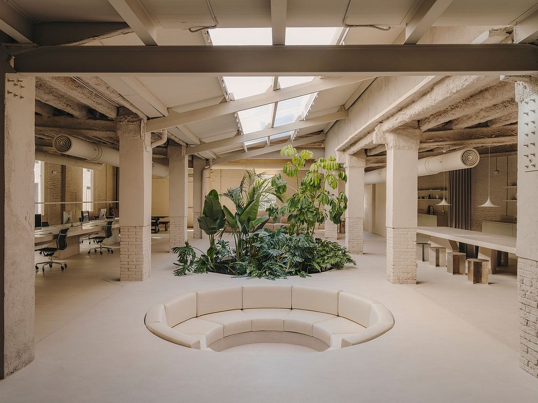Lush indoor garden with curving sofa and exposed brick walls, showcasing modern office design.
