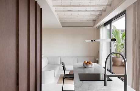 Minimalist living space with wooden panels, textured ceiling, and marble countertops.