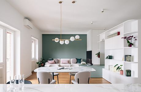 Elegant modern living room with statement lighting fixture and minimalist shelving.