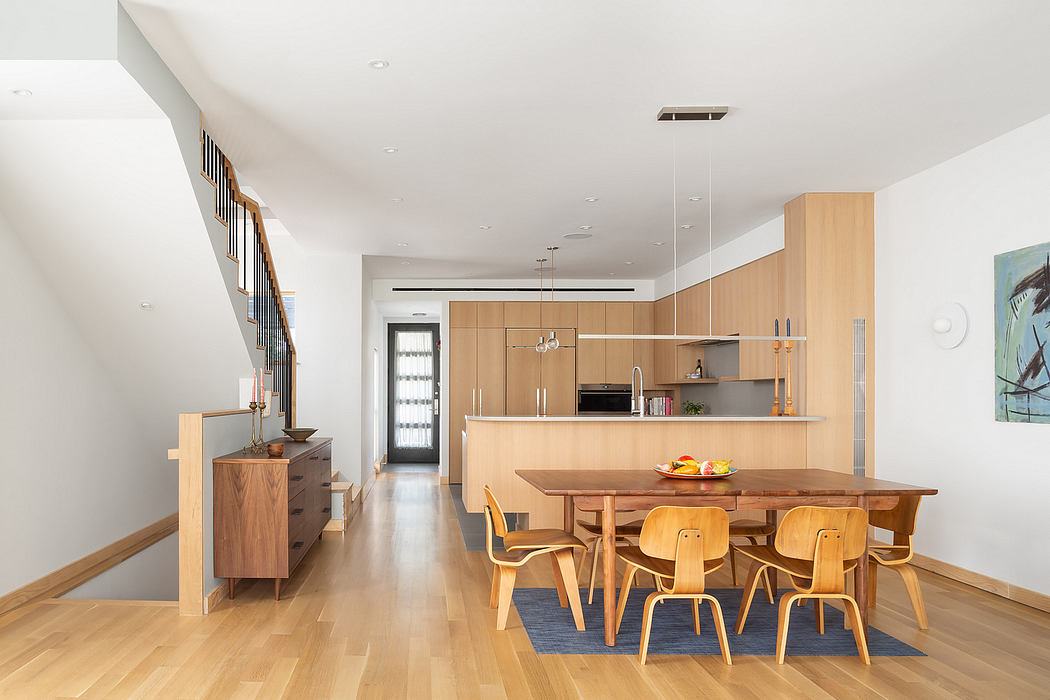 Contemporary open-plan kitchen and dining area with wooden furnishings and hardwood flooring.