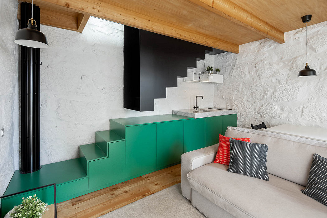 Cozy cabin interior with rustic wood ceiling, modern green cabinetry, and sleek staircases.