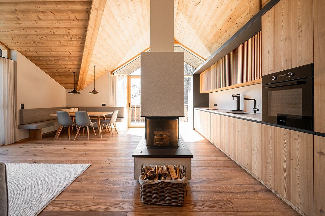 Rustic cabin interior with vaulted wooden ceiling, cozy fireplace, and modern kitchen.