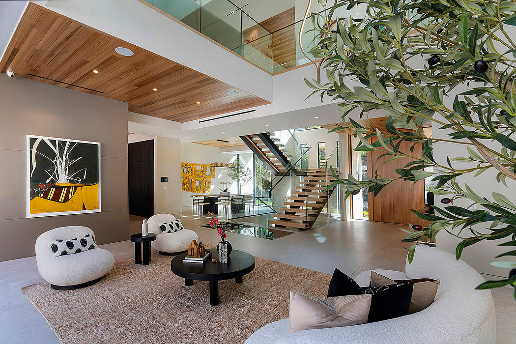 Spacious interior with glass staircase, modern furniture, and lush plants creating an airy, elegant ambiance.