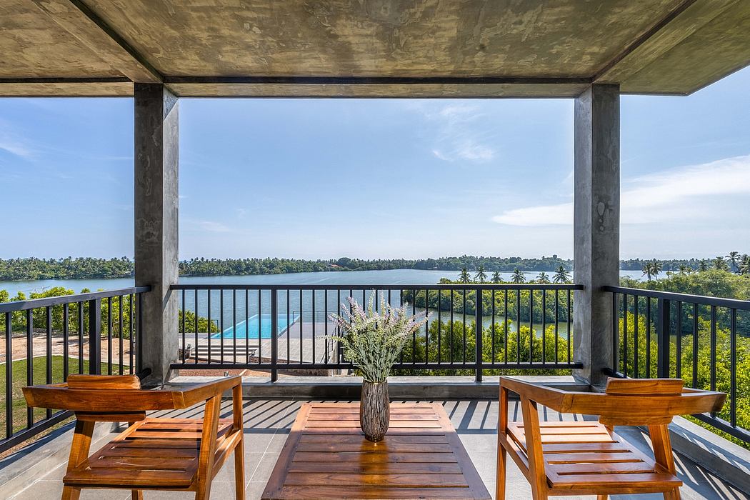 A covered patio with wooden furniture, overlooking a scenic lake and lush foliage.