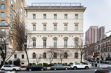 Elegant Beaux-Arts facade with ornate detailing and columns, set against modern city skyline.