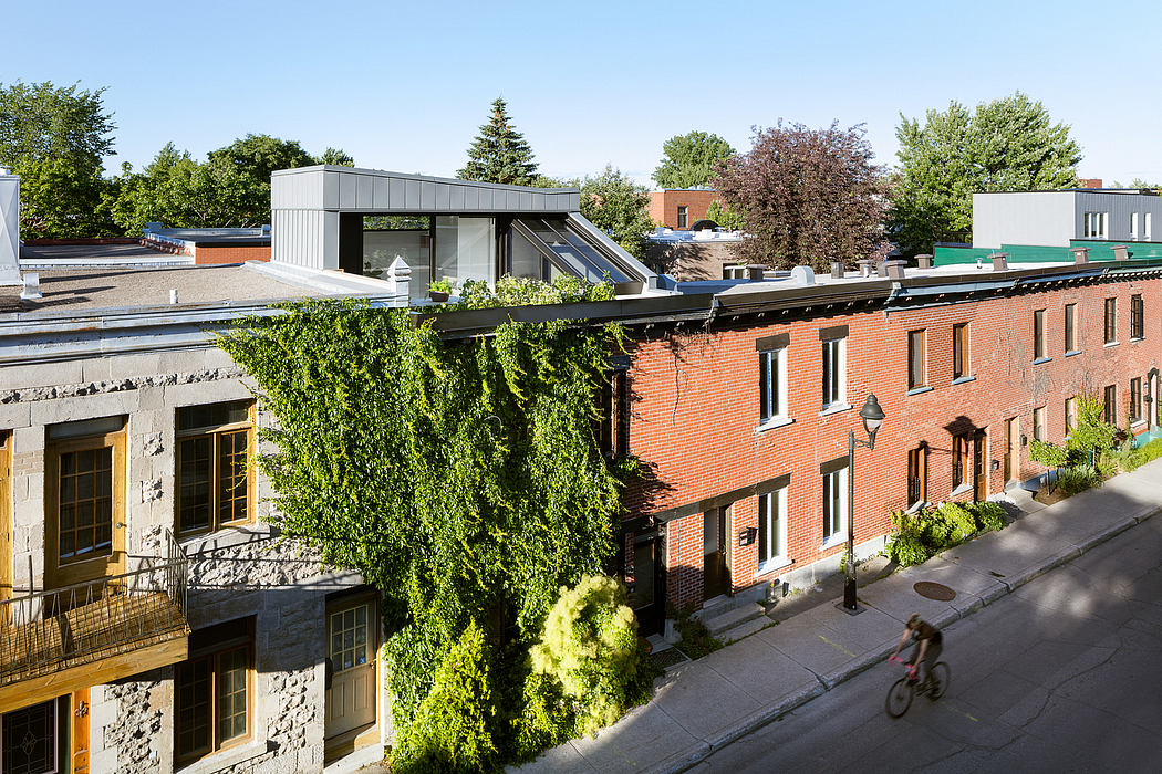 A modern structure with glass panels stands atop a row of historic brick buildings, complementing the urban landscape.