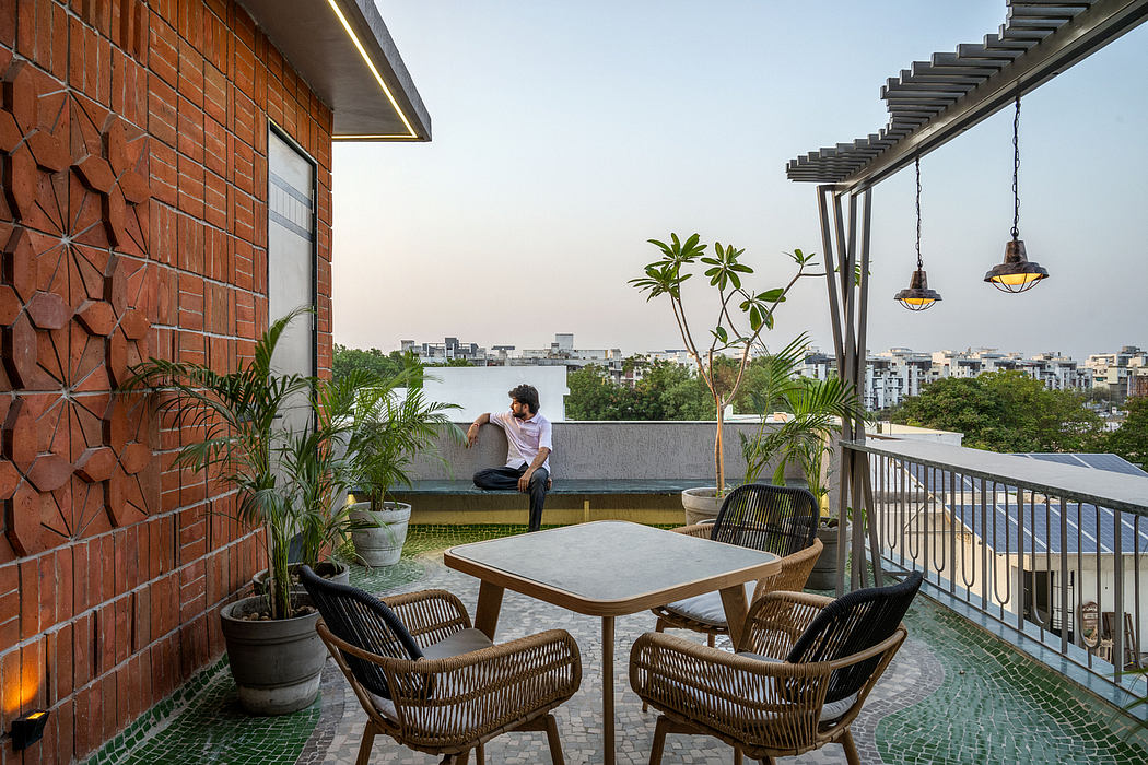 Modern rooftop terrace with brick walls, potted plants, outdoor furniture, and city view.