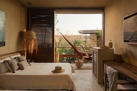 Rustic bedroom with floor-to-ceiling windows, wood furnishings, and lush outdoor view.