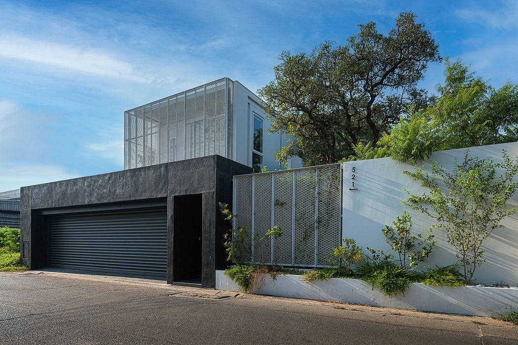Striking contemporary residence featuring a minimalist glass-and-steel facade framed by lush greenery.