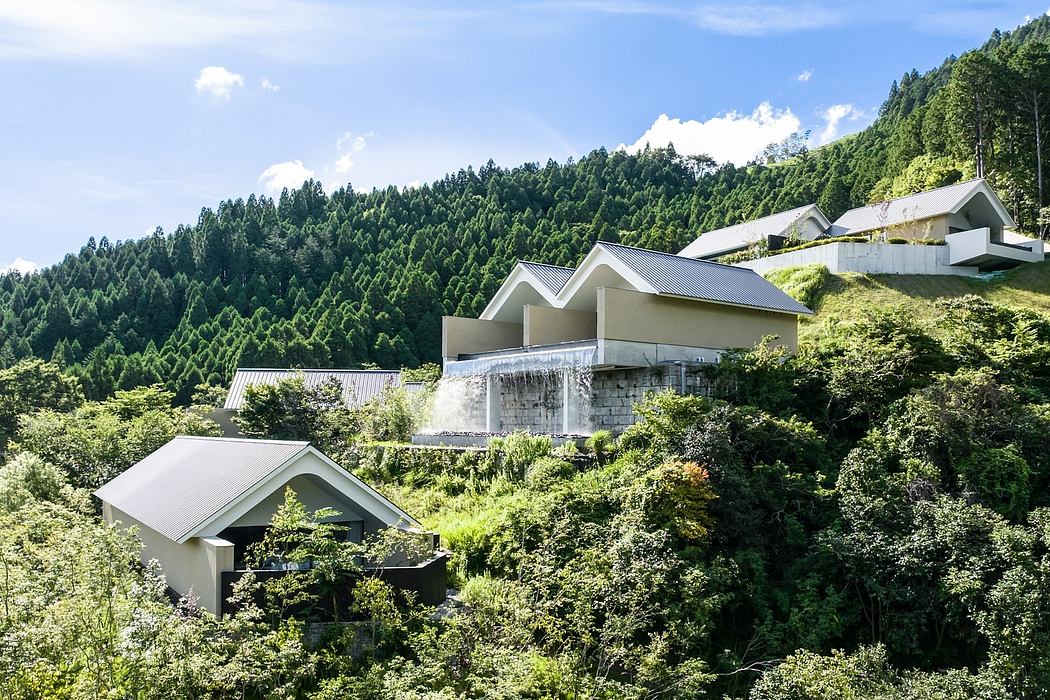 Captivating modern architecture nestled in lush, verdant hills with a cascading waterfall.
