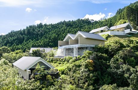 Captivating modern architecture nestled in lush, verdant hills with a cascading waterfall.