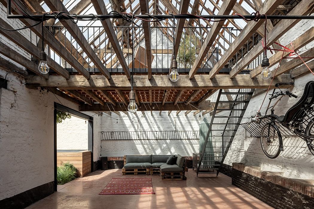 A rustic industrial loft with exposed wooden beams, metal staircase, and cozy seating.