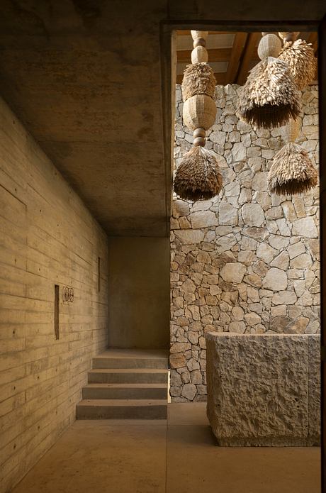 Stone walls, straw-like decorative elements, and an interior staircase create a rustic ambiance.