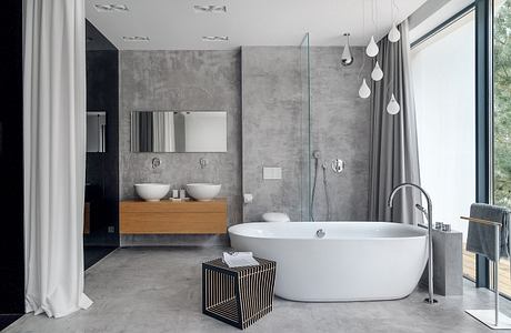 Modern minimalist bathroom design with concrete walls, freestanding tub, dual vanity.