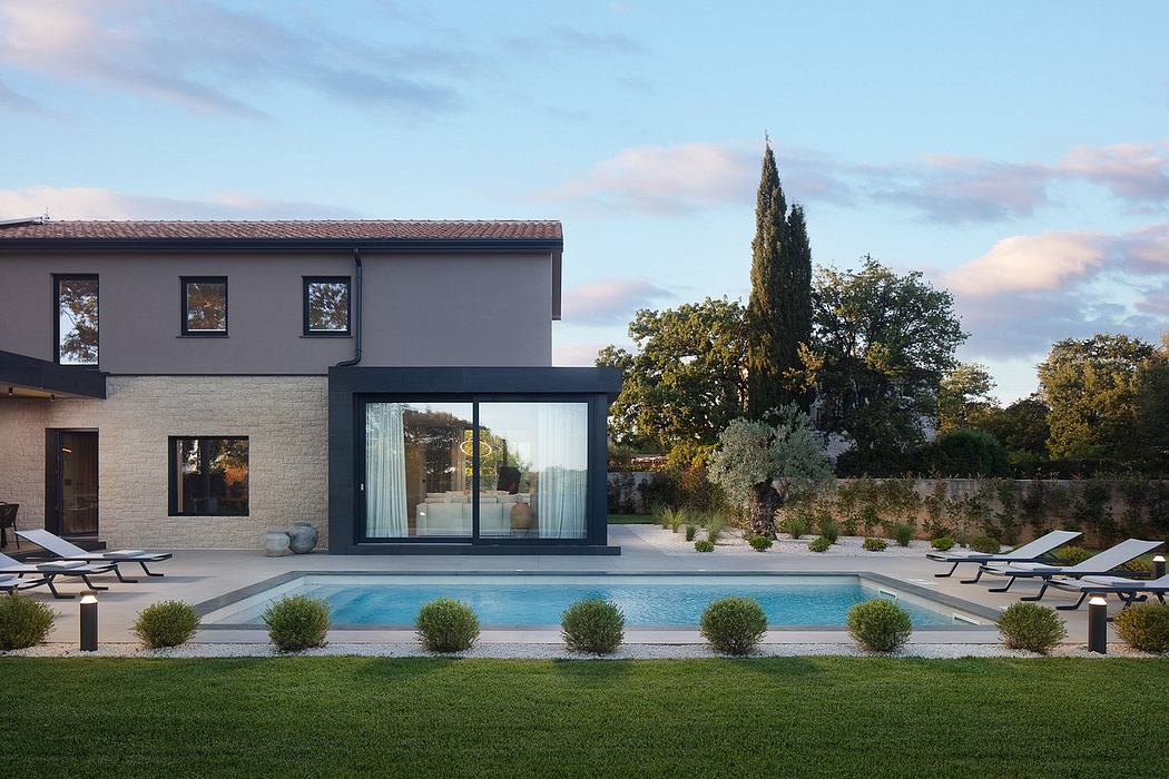 Sleek modern home with pool, landscaping, and large glass windows showcasing the exterior.