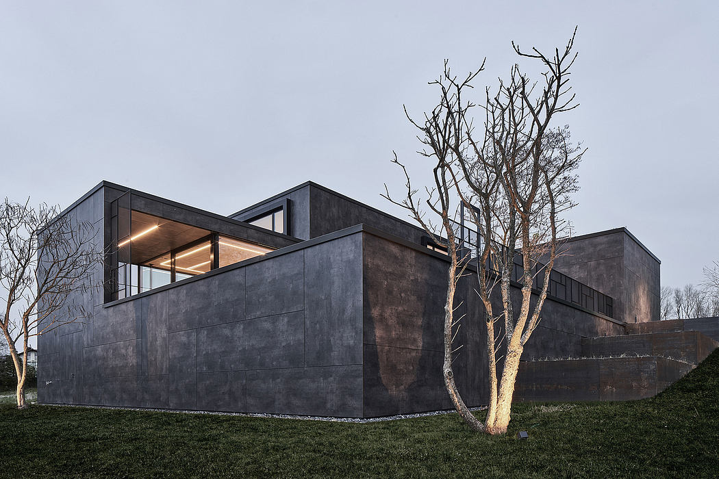 A unique, contemporary architectural design featuring dark, angular facades and large windows.