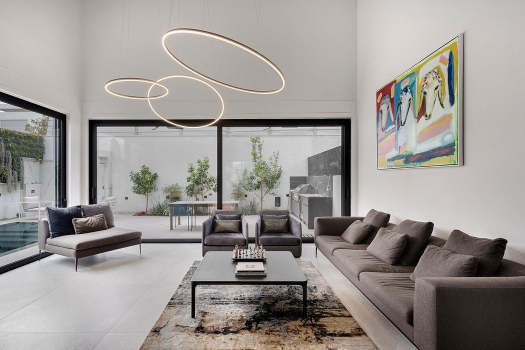 Modern, minimalist living room with sleek furniture, dramatic lighting fixtures, and abstract artwork.
