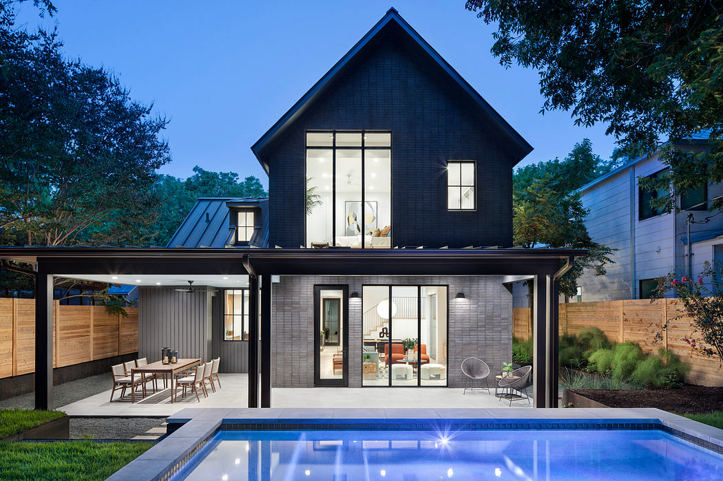 Beautiful black-and-white modern home with pool, outdoor dining area, and glass walls.