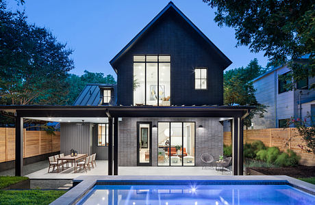 Beautiful black-and-white modern home with pool, outdoor dining area, and glass walls.