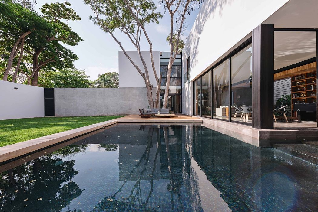 Modern residential architecture with a sleek glass exterior, private swimming pool, and lush landscaping.