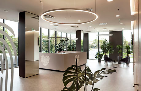 Sleek, modern lobby with circular lights, lush plants, and minimalist seating.