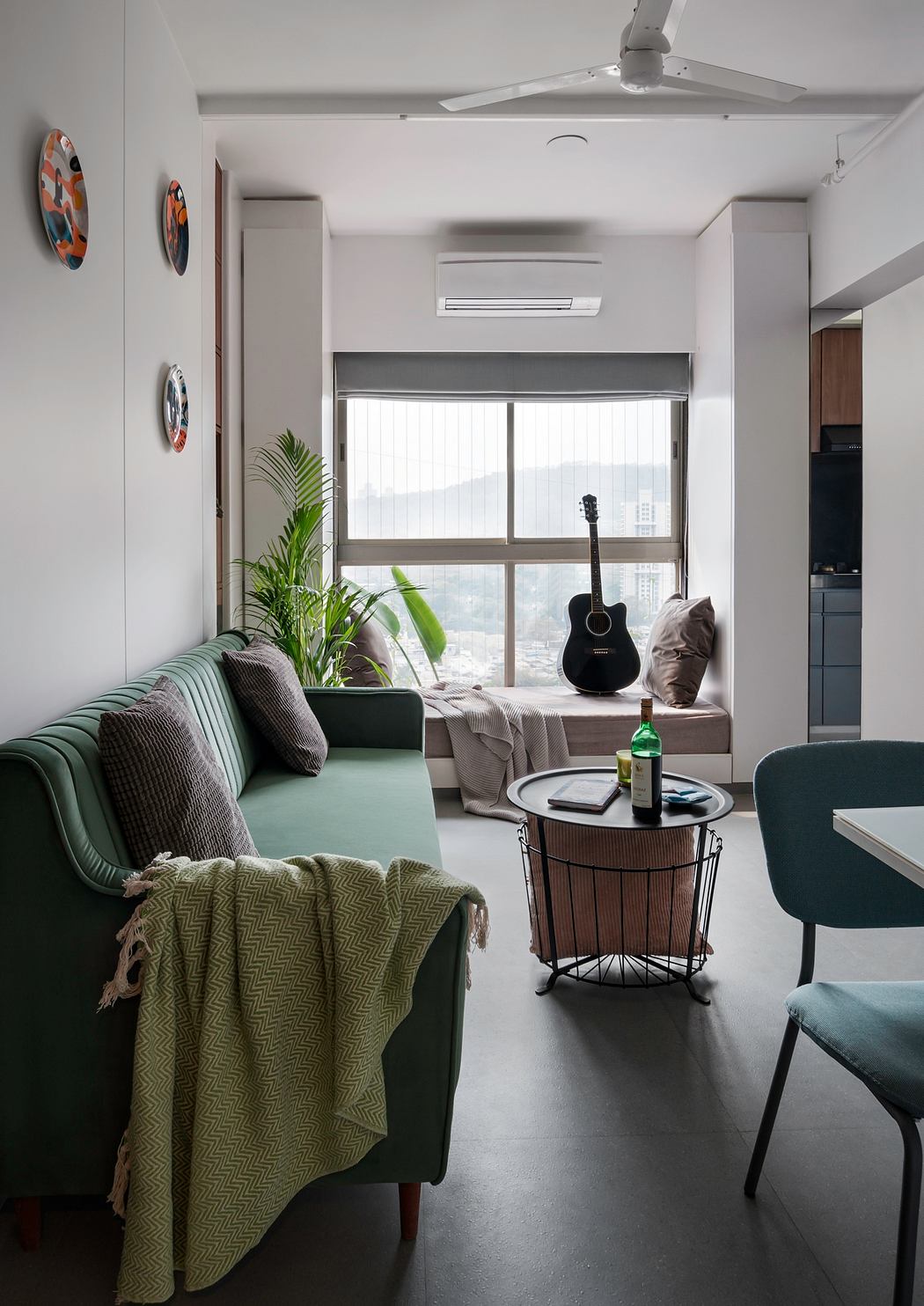 Cozy apartment with modern furnishings, large window, and acoustic guitar.