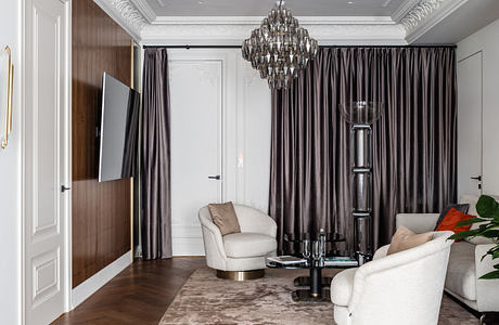 Luxurious living room with ornate ceiling, chandelier, and plush furnishings.