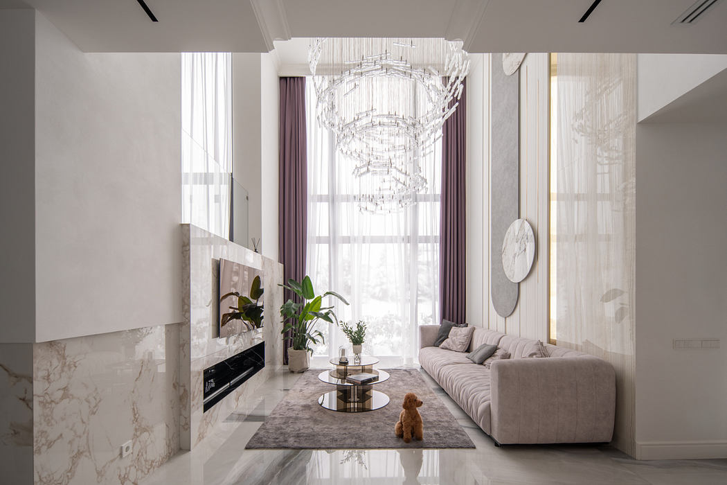 Elegant living room with marble accents, plush sofa, and a striking crystal chandelier.