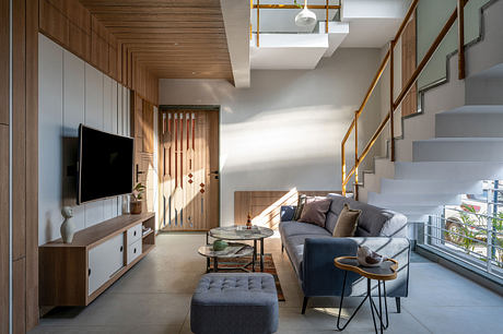 Cozy living room with wooden paneled walls, sleek furniture, and modern lighting.