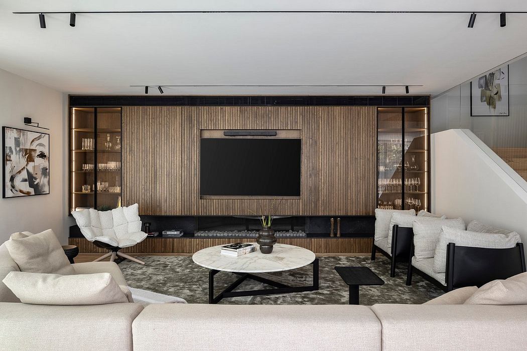 Spacious living room with modern wood-paneled media wall, track lighting, and minimalist furniture.