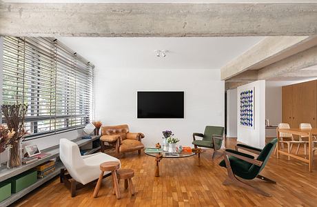 Stylish living room with eclectic mix of vintage and modern furnishings, hardwood floors.