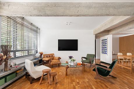 Stylish living room with eclectic mix of vintage and modern furnishings, hardwood floors.