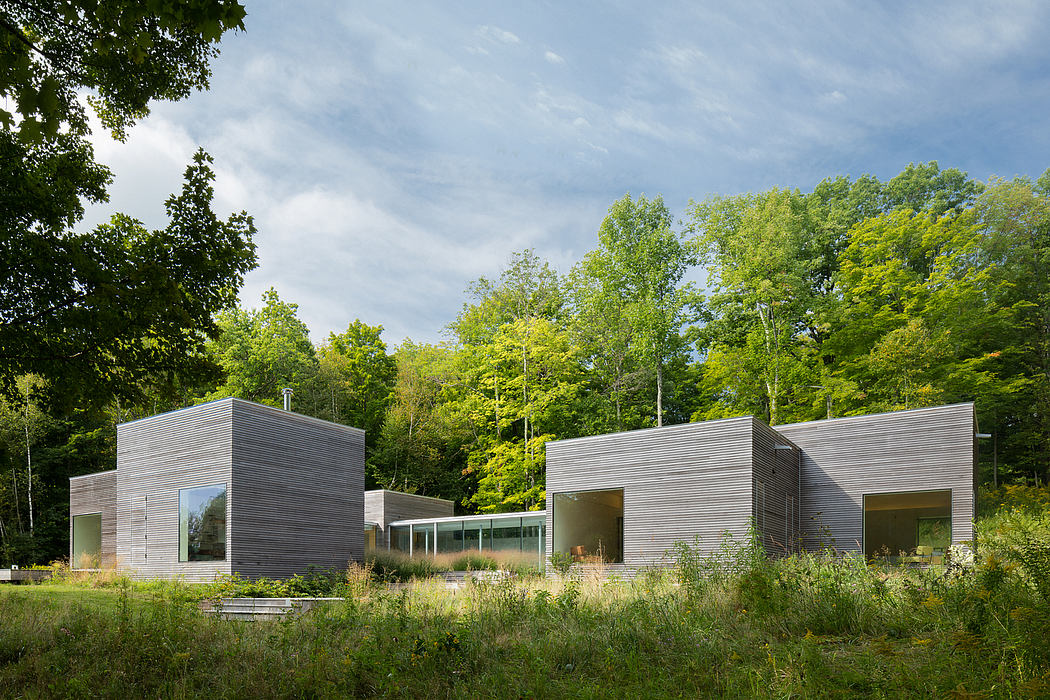 Modern, minimalist architectural design with sleek, rectangular structures amidst lush greenery.