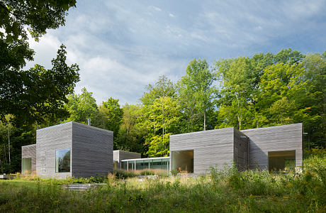 Modern, minimalist architectural design with sleek, rectangular structures amidst lush greenery.