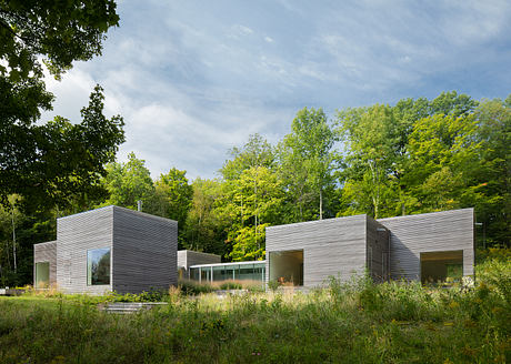 Modern, minimalist architectural design with sleek, rectangular structures amidst lush greenery.