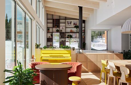 A spacious, modern interior with bright yellow piano, pink couch, and wooden shelving.