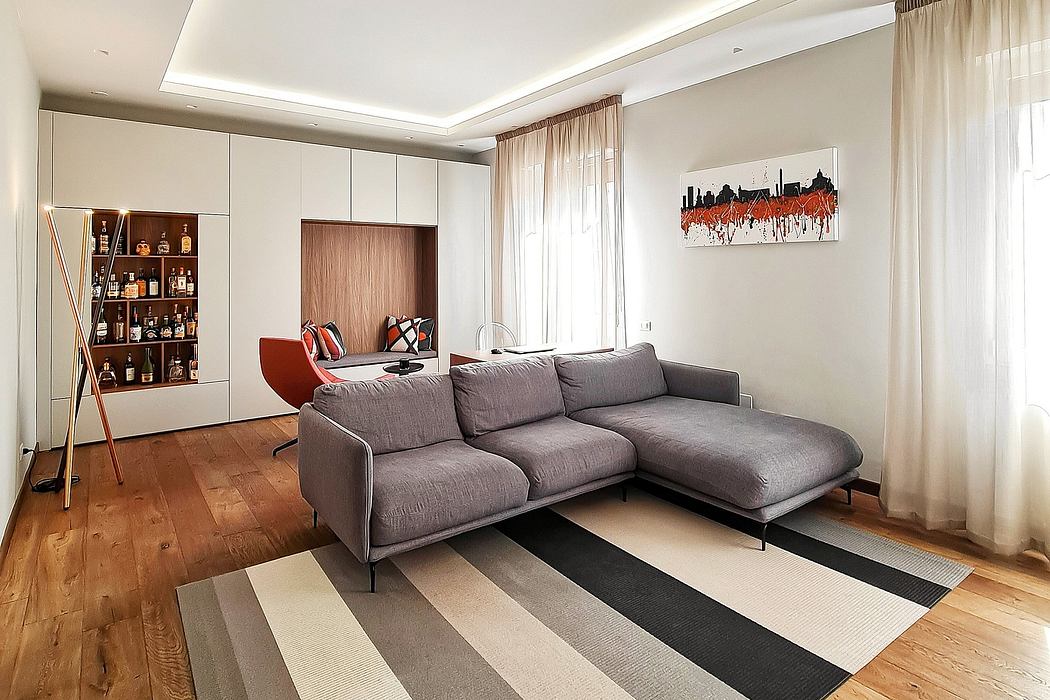 A modern living room with a gray sectional sofa, wall storage unit, and abstract artwork.