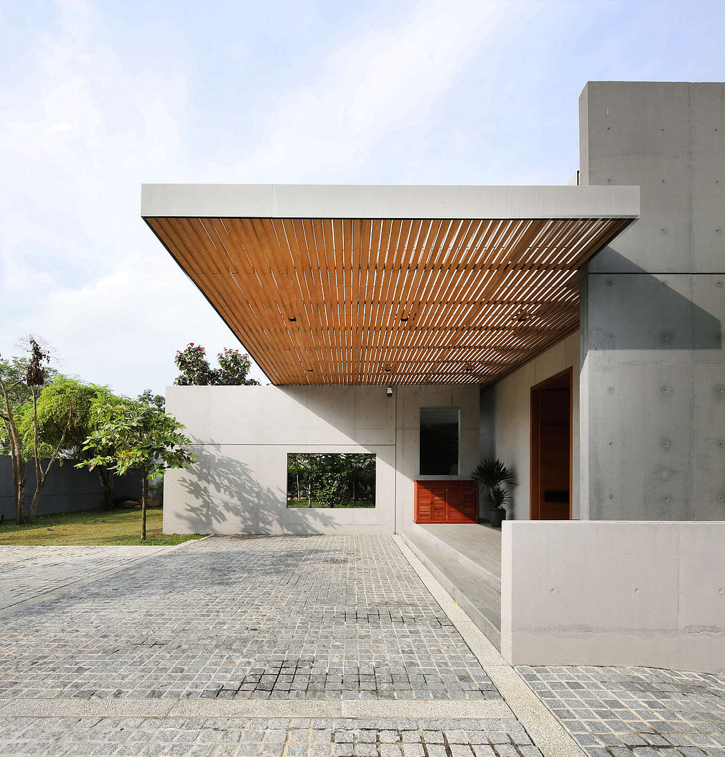 Sleek, modern architecture with a wooden slatted overhang, concrete walls, and paved garden path.